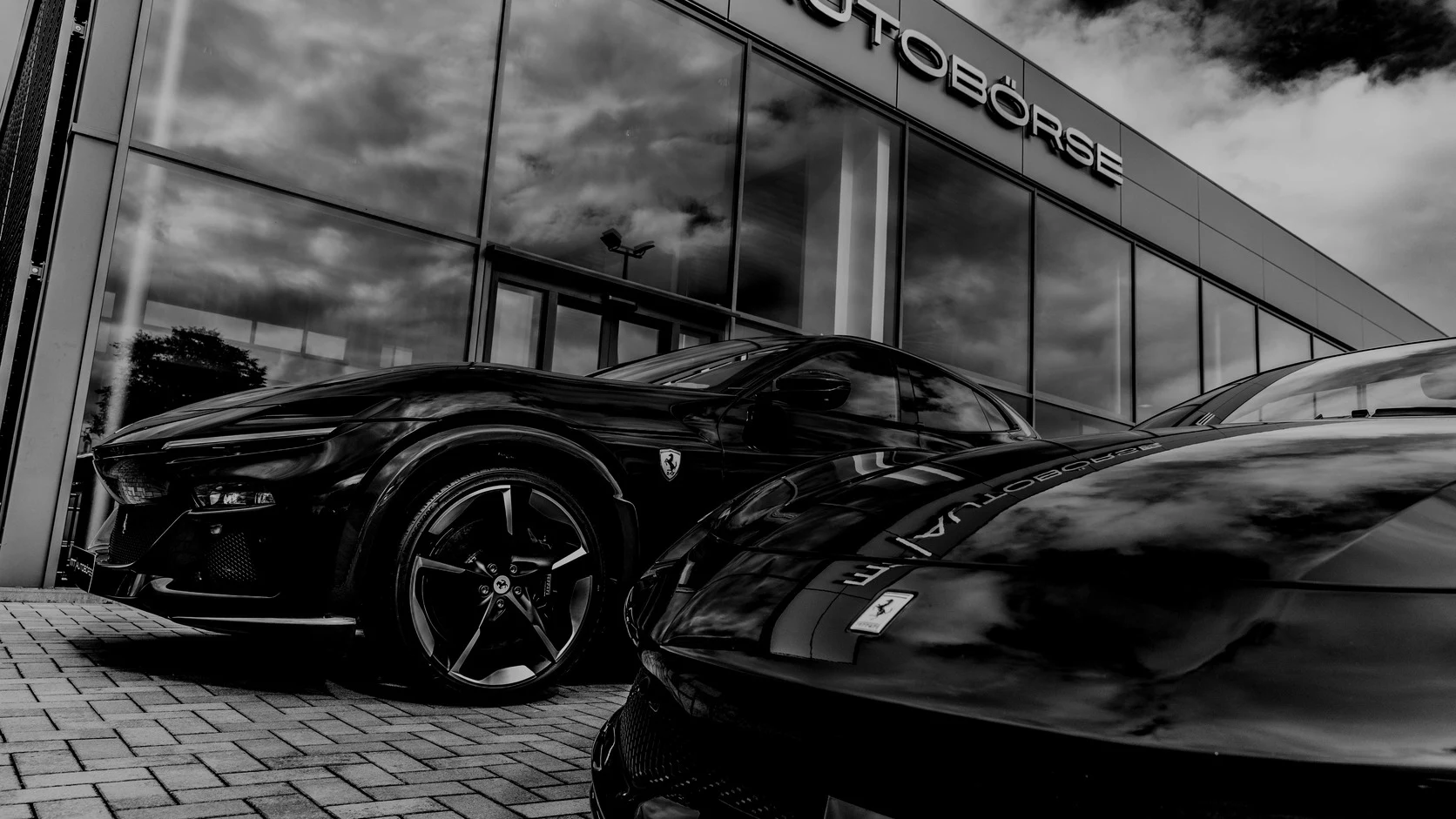 Porsche 911 Turbo S und Ferrari F8 Tributo im dunkel abgestimmten Showroom der MT Autobörse