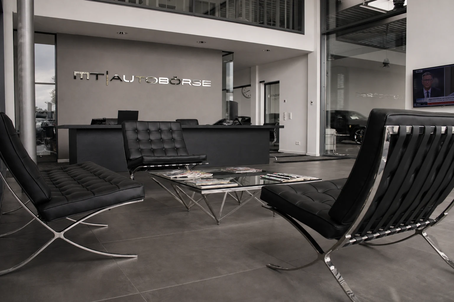 Kundenlounge der MT Autobörse mit schwarzen Sesseln und Glastisch